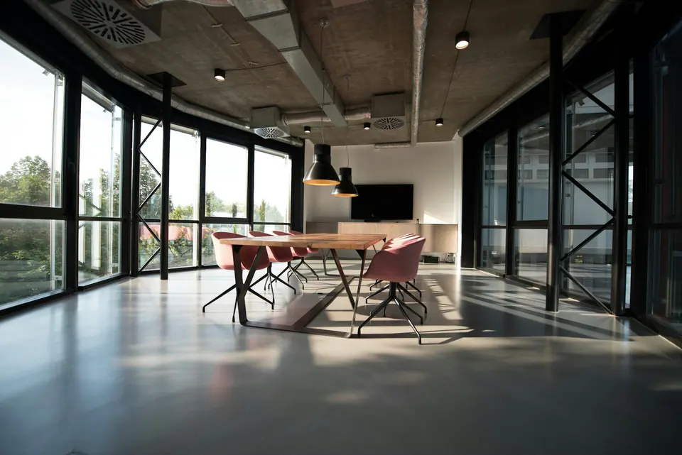 A communal timber table in a light-filled meeting room